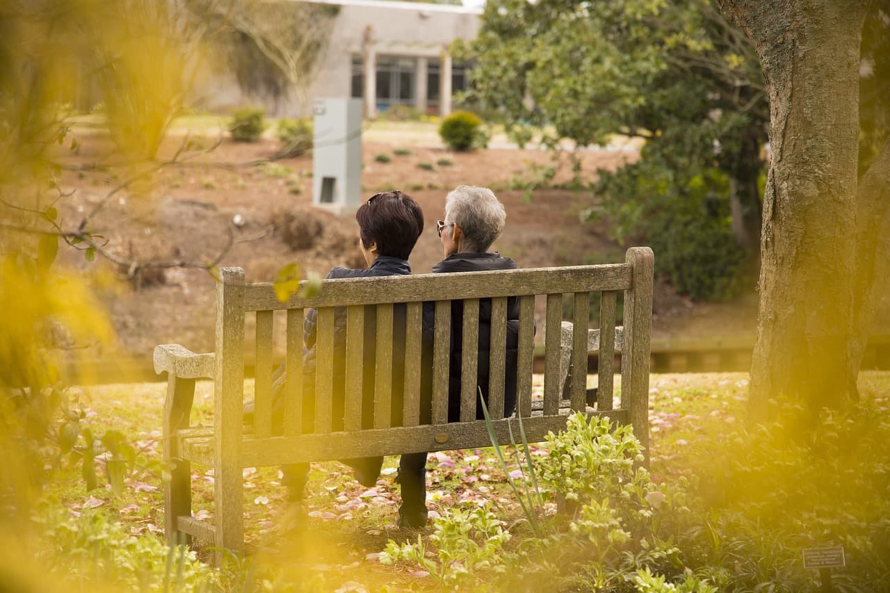 An older couple on a bench, considering what their estate will leave behind